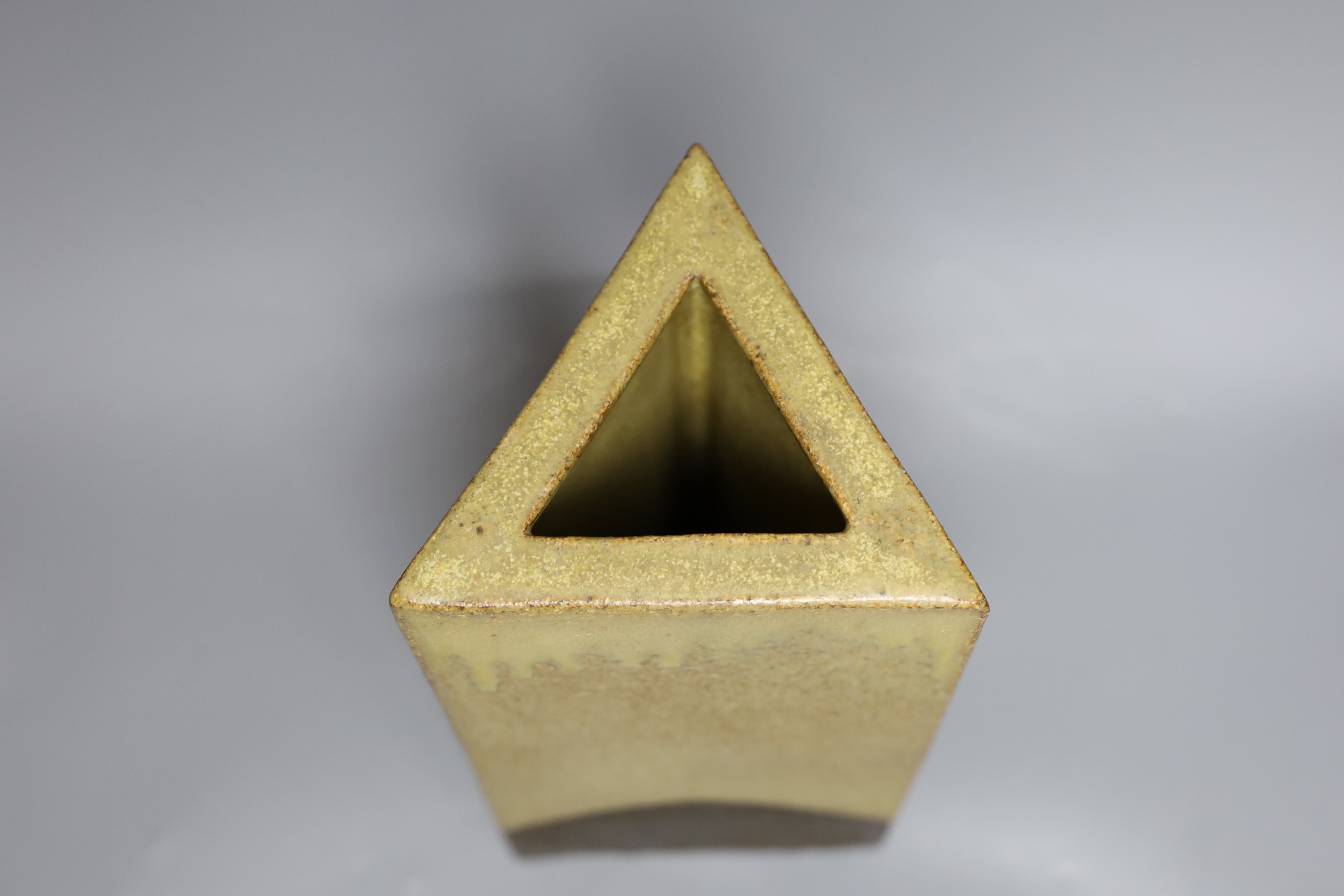 A glazed pottery triangular vase, inscribed Troika England 33cms high